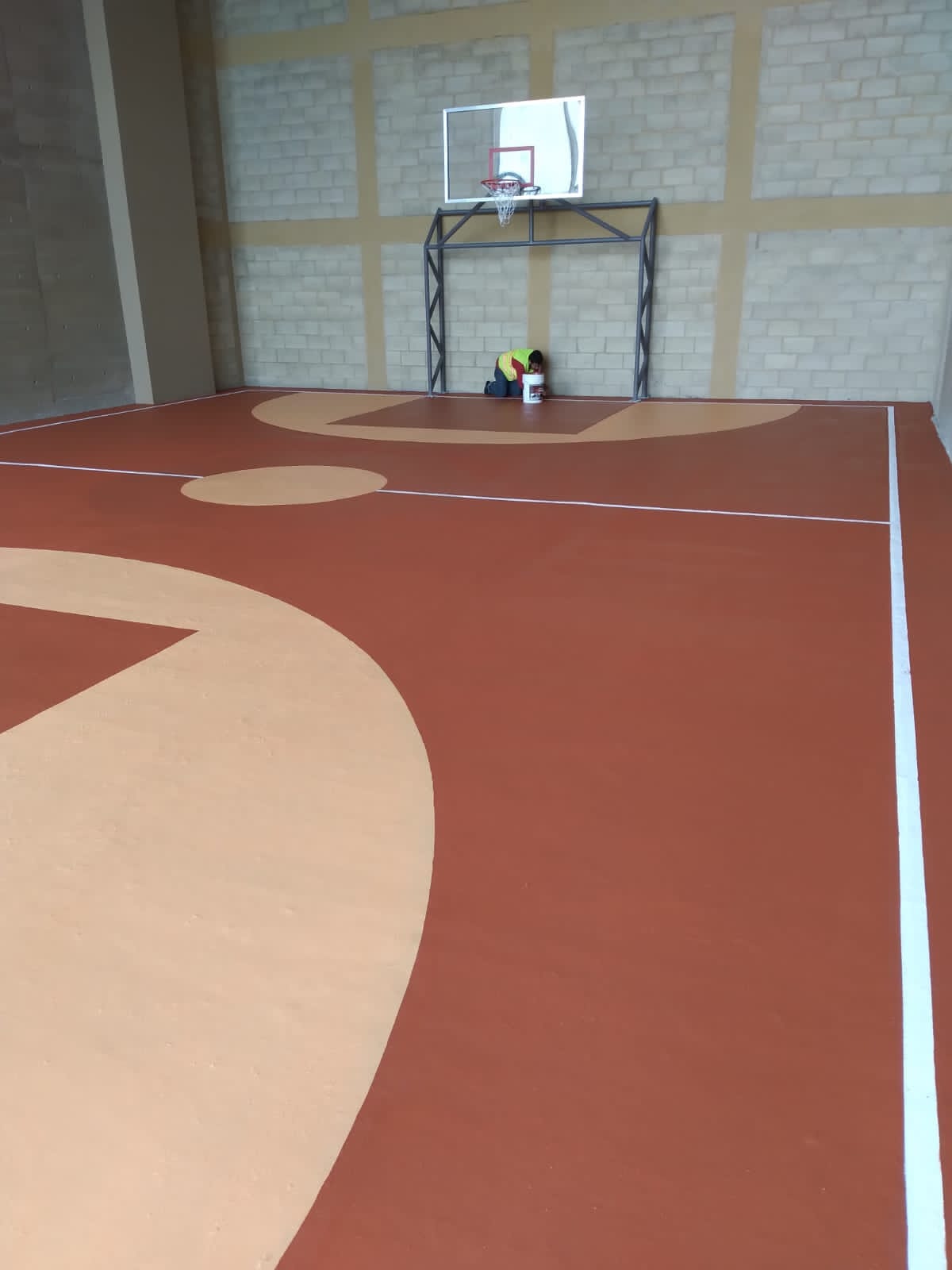 Cancha interior en tonos terracota y arena