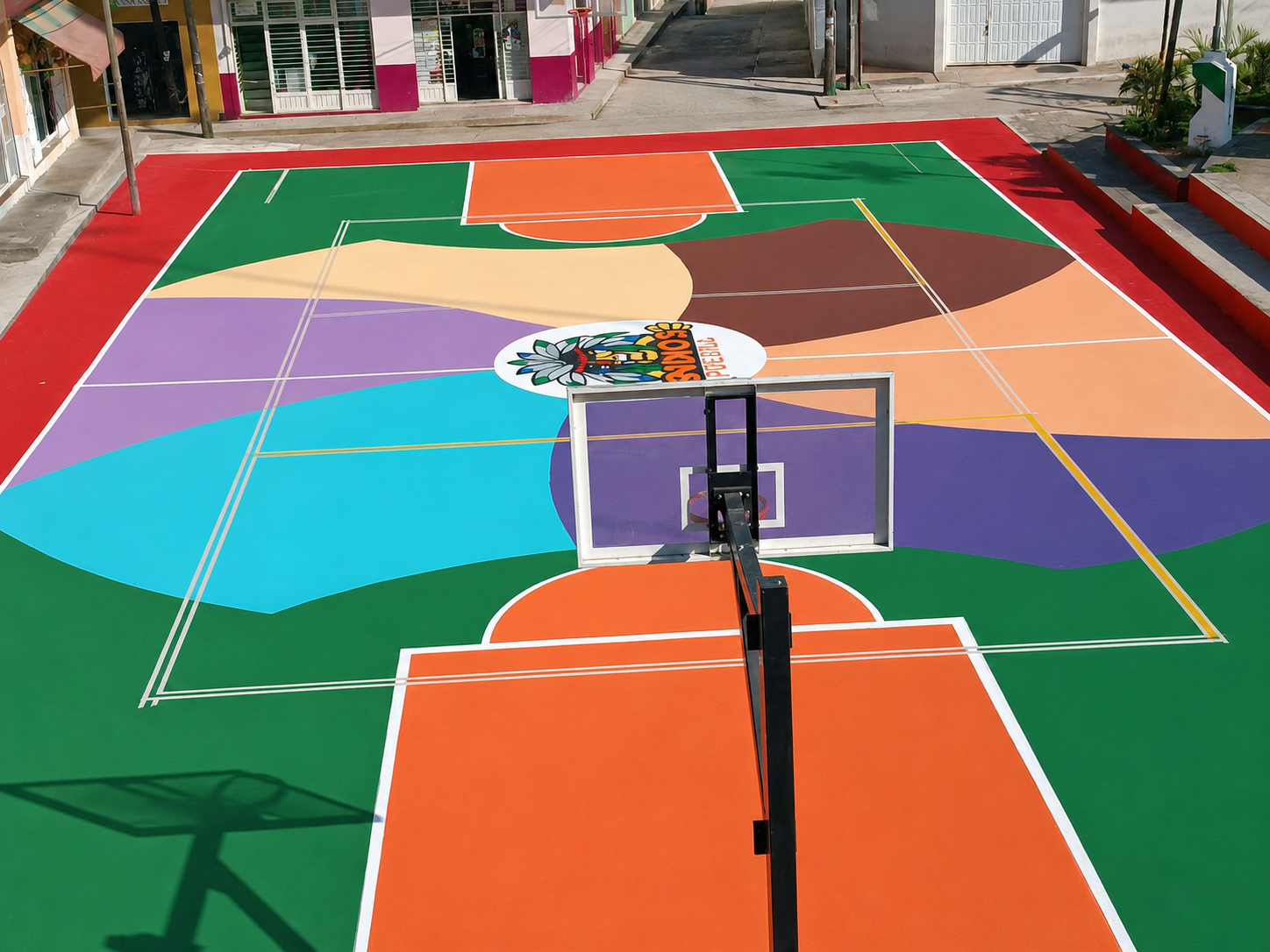 Cancha real con diseño artístico multicolor y emblema central